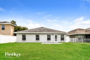 Auburndale house for rent - a white house with a grass yard and a white fence