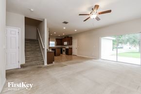 Windermere house for rent - A spacious living room with a staircase leading to the upper floor.