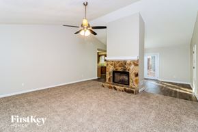 Powder Springs house for rent - a living room with a fireplace and a ceiling fan
