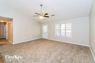 Powder Springs house for rent - a spacious living room with carpet and a ceiling fan