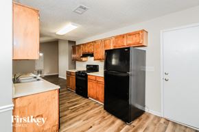 Powder Springs house for rent - a kitchen with wooden cabinets and a black refrigerator