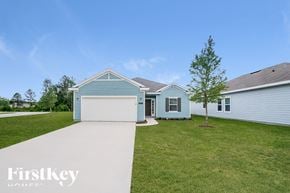 Jacksonville house for rent - A blue house with a white garage door and a tree in front of it.