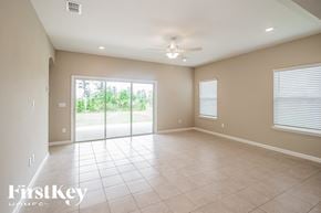 Jacksonville house for rent - A spacious room with a ceiling fan and sliding glass doors.