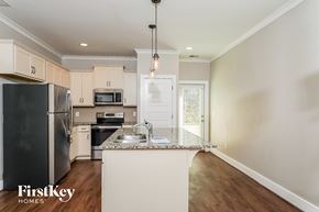 Birmingham house for rent - a kitchen with white cabinets and stainless steel appliances