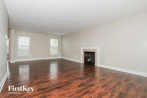 Morrow house for rent - A spacious room with wooden floors and a fireplace.