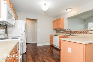 Morrow house for rent - A kitchen with wooden cabinets and a white fridge.