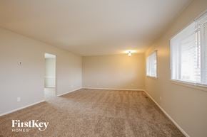 Indianapolis house for rent - A spacious room with carpeted floor and a window with blinds.