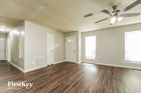 Lithonia house for rent - an empty living room with wood floors and a ceiling fan
