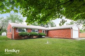 Indianapolis house for rent - A red brick house with a white garage door.