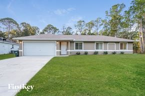 North Port house for rent - a home with a lawn and a white garage door