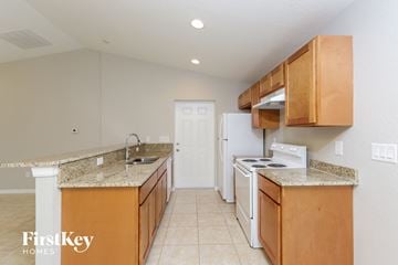 North Port house for rent - a kitchen with white appliances and granite counter tops