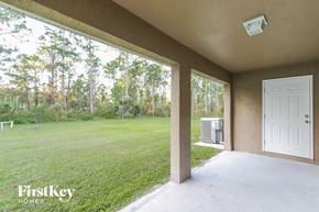 North Port house for rent - a covered porch with a grassy yard and a white door