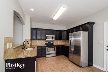 Bessemer house for rent - A kitchen with a granite countertop and a refrigerator.