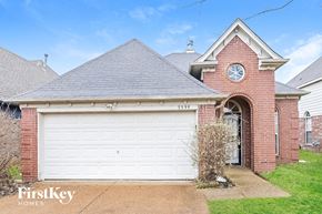 Memphis house for rent - A brick house with a white garage door and a clock on the wall.