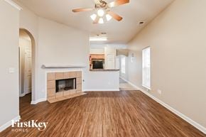 Memphis house for rent - A spacious living room with a fireplace and a ceiling fan.