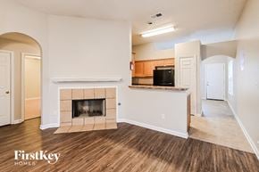 Memphis house for rent - A living room with a fireplace and a kitchen in the background.