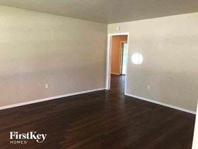 Fort Worth house for rent - an empty living room with white walls and wood floors