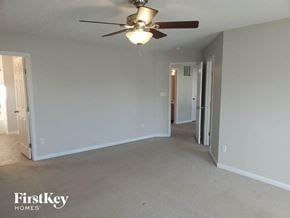 Maineville house for rent - A spacious room with a ceiling fan and beige carpeting.