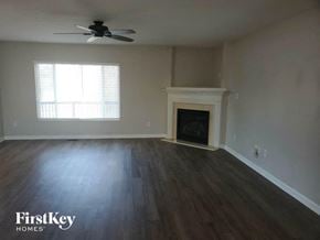 Maineville house for rent - A room with a fireplace and a ceiling fan.