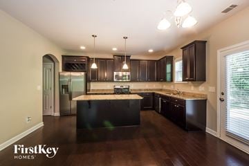 Charlotte house for rent - a large kitchen with dark wood cabinets and granite counter tops