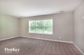 Charlotte house for rent - a bedroom with a large window and a carpeted floor