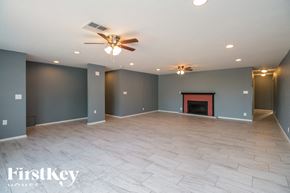 Phoenix house for rent - A spacious room with a fireplace and a ceiling fan.