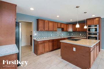 Phoenix house for rent - A kitchen with wooden cabinets and a blue backsplash.