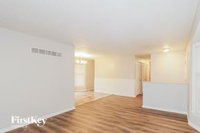 Kansas City house for rent - A spacious room with wooden flooring and white walls, with a doorway leading to another room.