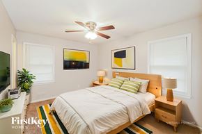 Kansas City house for rent - A bedroom with a bed, nightstand, and a ceiling fan.