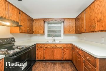 Indianapolis house for rent - A kitchen with wooden cabinets and a black stove top.