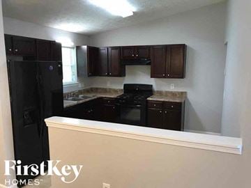 Stone Mountain house for rent - A kitchen with a black fridge and black oven.