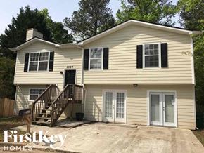 Stone Mountain house for rent - A two-story house with a garage on the first floor and a balcony on the second floor.