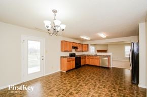 Indianapolis house for rent - A kitchen with a tile floor and wooden cabinets.