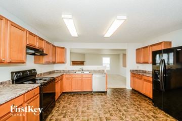 Indianapolis house for rent - A kitchen with orange cabinets and black appliances.