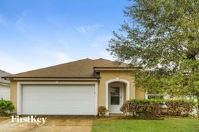Jacksonville house for rent - A house with a garage door and a tree in front.