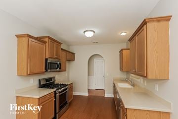 Atlanta house for rent - a kitchen with wooden cabinets and white counter tops and a stove top oven