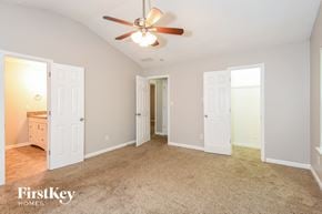 Atlanta house for rent - a bedroom with white doors and a ceiling fan