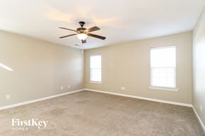 Clemmons house for rent - A spacious room with a ceiling fan and two windows.