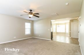 Clemmons house for rent - A spacious room with a ceiling fan and a door leading to another room.