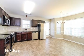 Clemmons house for rent - A kitchen with brown cabinets and a black counter top.