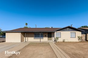 Phoenix house for rent - A house with a brown roof and a beige exterior is shown with a clear blue sky in the background.