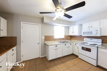 Phoenix house for rent - A kitchen with white cabinets and appliances, a ceiling fan, and a tile floor.