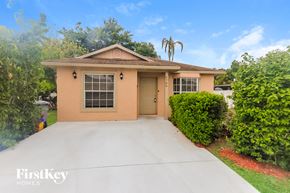 Boynton Beach house for rent - a beige home with a driveway and a palm tree