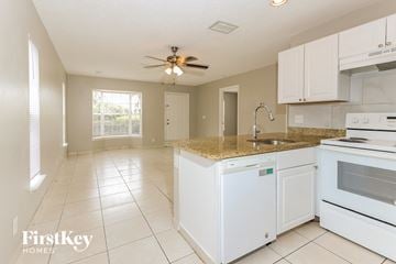 Boynton Beach house for rent - a kitchen with white appliances and a granite counter top