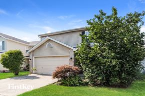 Loveland house for rent - A house with a garage and a tree in front of it.