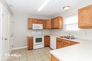 Loveland house for rent - A kitchen with wooden cabinets and white appliances.