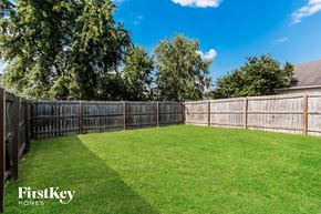 Loveland house for rent - A backyard with a wooden fence and a grassy area.