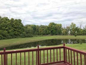 Indianapolis house for rent - A red railing overlooks a pond with trees in the background.