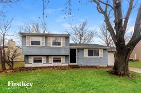 Indianapolis house for rent - A two-story house with a grey exterior and a tree in front.