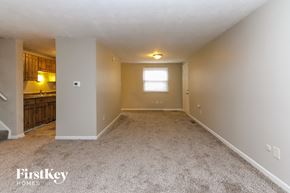 Indianapolis house for rent - A spacious room with a carpeted floor and a window.